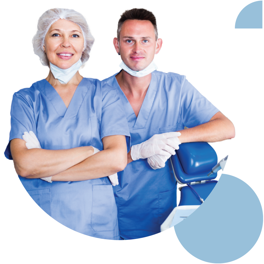 Two dental providers posing next to dental chair